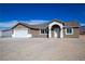 Inviting single-story home boasts an arched entryway and well-maintained gravel landscaping at 5841 Genoa Ave, Pahrump, NV 89060