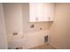 Bright laundry room featuring a sink, utility connections, and ample white storage cabinets at 5841 Genoa Ave, Pahrump, NV 89060