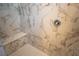 Close-up of marble tiled shower featuring a built-in seat, decorative tile accents, and modern fixtures at 5841 Genoa Ave, Pahrump, NV 89060