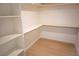 Walk-in closet with open shelving, wood-look flooring, and ample storage space at 5841 Genoa Ave, Pahrump, NV 89060