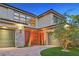 Close-up of the three-car garage with stone accents and a well-maintained lawn at 65 Garibaldi Way, Henderson, NV 89011