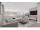Virtually staged living room with sectional sofa and large TV at 65 Garibaldi Way, Henderson, NV 89011