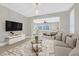 Virtually staged living room with view into main bedroom at 65 Garibaldi Way, Henderson, NV 89011