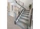 Modern staircase with metal railing and grey carpet at 65 Garibaldi Way, Henderson, NV 89011
