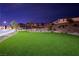 Night view of community park with artificial turf, landscaping, and homes in background at 7044 Stockton Dunes St, North Las Vegas, NV 89084