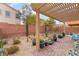 Cozy backyard with desert landscaping, potted plants, brick patio, and a pergola at 7481 Benlomond Ave, Las Vegas, NV 89179