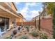 Picturesque backyard featuring desert landscaping, brick patio beneath pergola, and a view of neighboring homes at 7481 Benlomond Ave, Las Vegas, NV 89179