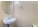 Powder bathroom featuring a pedestal sink with brushed nickel hardware and a round mirror at 7481 Benlomond Ave, Las Vegas, NV 89179