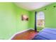 Bedroom with green walls, hardwood floors, and large window at 7481 Benlomond Ave, Las Vegas, NV 89179