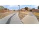 Neighborhood walking path bordered by desert landscaping, walls, and grass at 7481 Benlomond Ave, Las Vegas, NV 89179