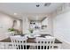 Open kitchen with white cabinets and a breakfast bar overlooking the dining area at 7660 Fabled Filigree St, Las Vegas, NV 89149