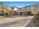 Contemporary home with clean lines, a stone facade, and a spacious driveway with beautiful landscaping at 82 Glade Hollow Dr, Las Vegas, NV 89135