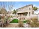 Landscaped backyard with artificial turf, rock feature, and a two-story house at 989 Crescent Falls St, Henderson, NV 89011