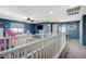 Upstairs hallway with gray carpet, white railings, and blue walls at 10191 Cougar Crossing St, Las Vegas, NV 89178