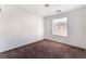 Bright bedroom with brown carpet and a large window at 10441 Concetta Ave, Las Vegas, NV 89129