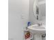 Small bathroom with pedestal sink and round mirror at 10691 Sariah Skye Ave, Las Vegas, NV 89166