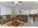 Relaxing living room with gray leather couches and a ceiling fan at 10691 Sariah Skye Ave, Las Vegas, NV 89166