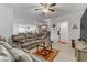 Bright living room with leather sofas, a ceiling fan, and views to kitchen at 10691 Sariah Skye Ave, Las Vegas, NV 89166