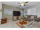 Living room with leather couches, a large TV, and a ceiling fan at 10691 Sariah Skye Ave, Las Vegas, NV 89166