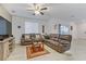 Spacious living room featuring leather reclining sofas and a ceiling fan at 10691 Sariah Skye Ave, Las Vegas, NV 89166