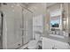 Bright bathroom featuring a tiled shower with glass doors and a modern vanity with marble countertop at 10896 Tranquil Hills Way, Las Vegas, NV 89135