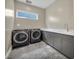 Modern laundry room with gray cabinets and high-end appliances at 10896 Tranquil Hills Way, Las Vegas, NV 89135