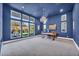 Bright home office featuring a stunning blue accent wall, large windows, and a modern chandelier at 10896 Tranquil Hills Way, Las Vegas, NV 89135