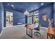 Well-lit home office featuring a fireplace, chandelier, carpeted floors, and ample space at 10896 Tranquil Hills Way, Las Vegas, NV 89135