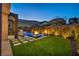 Evening view of a luxurious pool and patio area with fire pits at 10896 Tranquil Hills Way, Las Vegas, NV 89135