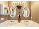 Bathroom with double sinks, oval mirrors, and light brown vanity at 1411 E Blosser Ranch Rd, Pahrump, NV 89060