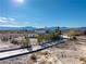 House with a long driveway, landscaping and mountain views in the background at 1411 E Blosser Ranch Rd, Pahrump, NV 89060