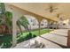 Spacious covered back patio with lush landscaping and ceiling fans at 221 Raptors View Ave, Las Vegas, NV 89031