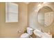 Powder room featuring a white toilet, sink, and fixtures under soft lighting and a window at 221 Raptors View Ave, Las Vegas, NV 89031