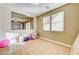 Bedroom with neutral walls, tile flooring, bright sunlight through windows, and a partial open view at 221 Raptors View Ave, Las Vegas, NV 89031