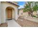 Light brown front door with stone pathway and surrounding landscaping at 221 Raptors View Ave, North Las Vegas, NV 89031