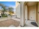 The front entrance is framed by elegant arches, a neutral stucco facade and xeriscaped yard at 221 Raptors View Ave, Las Vegas, NV 89031