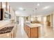 Open-concept kitchen with granite counters, pendant lights, seamlessly connects to the living room creating an inviting space at 221 Raptors View Ave, Las Vegas, NV 89031