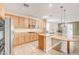 Kitchen with stainless steel appliances, wood cabinets, granite countertops, and an island with pendant lights at 221 Raptors View Ave, Las Vegas, NV 89031