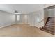 Bright living room with neutral walls, tile flooring, ceiling fan and wooden staircase at 221 Raptors View Ave, Las Vegas, NV 89031