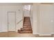 Staircase with wooden steps and a wooden handrail in a hallway with a white door and light-colored walls at 221 Raptors View Ave, Las Vegas, NV 89031