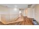 Upstairs hallway with hardwood floors and a wooden railing overlooking the staircase at 221 Raptors View Ave, North Las Vegas, NV 89031