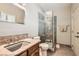 Well-lit bathroom boasts granite countertop, gray tile flooring, glass enclosed shower, and neutral color palette at 24 Wild Dunes Ct, Las Vegas, NV 89113