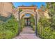 Elegant entryway with stone archway and wrought iron gate leading to front door at 24 Wild Dunes Ct, Las Vegas, NV 89113