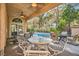 Relaxing outdoor covered patio includes a ceiling fan, multiple seating areas, and a view of the pool at 24 Wild Dunes Ct, Las Vegas, NV 89113