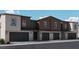 Modern three-unit townhome building with attached garages and desert landscaping at 2558 Petunia Garden Ave # 217, North Las Vegas, NV 89081