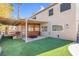 Backyard patio with wooden pergola, artificial turf and privacy fence at 2619 Grey Stone Rd, Henderson, NV 89074