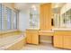 Bathroom with double vanity, soaking tub, and window with shutters at 3 Glendora Ct, Henderson, NV 89052