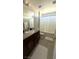 Well-lit bathroom features a single sink vanity with granite countertop and a shower-tub combination at 3041 Savella Ave, Henderson, NV 89044