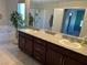 Double vanity bathroom with granite countertop and large mirror at 3041 Savella Ave, Henderson, NV 89044