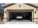 Open two-car garage featuring a parked SUV, neutral paint, stone trim, and outdoor lanterns at 3041 Savella Ave, Henderson, NV 89044